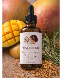 Bottle of Crown Growth Oil with mangoes and herbs in the background